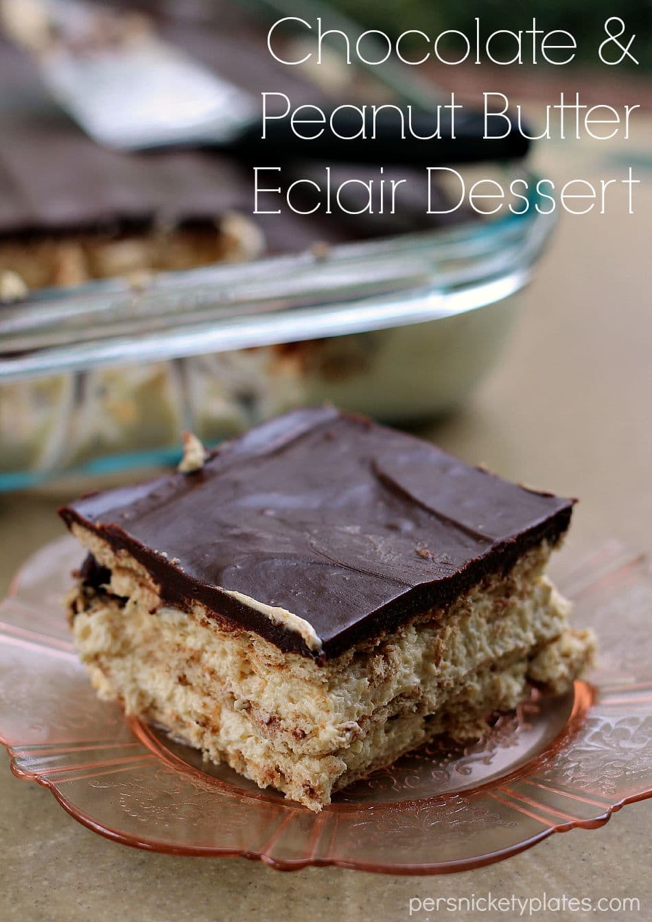 This no bake Chocolate and Peanut Butter Eclair Dessert has layers of graham crackers, layers of peanut butter pudding, a sprinkling of mini chocolate chips, and a chocolate peanut butter frosting. It's a chocolate + peanut butter lovers dream. | www.persnicketyplates.com slice of chocolate eclair dessert with layers of peanut butter pudding on pink plate