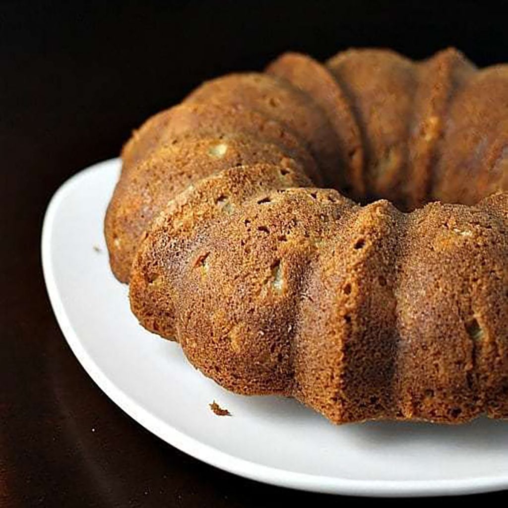 apple bundt cake on white platter.