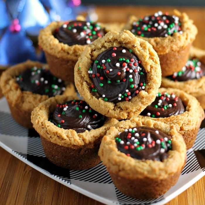 stack of peanut butter cookie cups filled with chocolate & topped with christmas sprinkles
