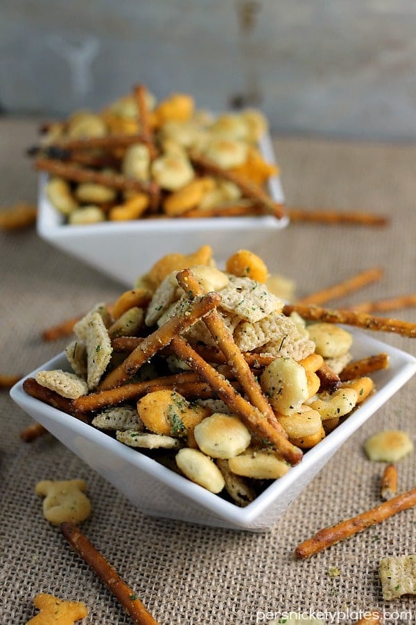 white bowl filled with pretzel sticks, oyster crackers, chex cereal, and ranch seasoning