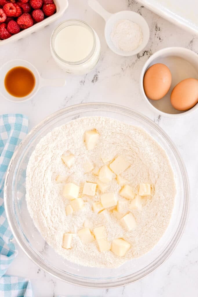cubed butter in a mixing bowl with a a flour mixture.