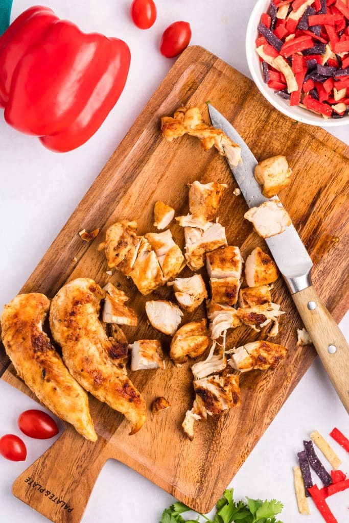 sliced chicken on a wood cutting board.