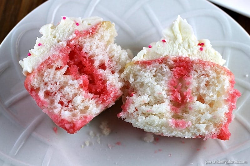 Strawberry Jello Poke Cupcakes start with a white cake mix but are jazzed up when you poke holes in them and pour on some strawberry Jello. It makes for a really moist, flavorful, and pretty cupcake! | Persnickety Plates