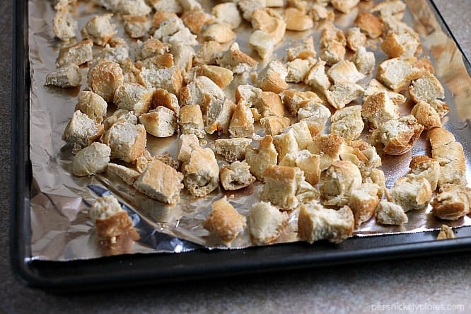 Traditional Herb Stuffing is very easy to make and filled with fresh, flavorful herbs. It'll be a hit on any Thanksgiving table! | www.persnicketyplates.com #thanksgiving #stuffing #herbstuffing #easyrecipe #sidedish dried bread on baking sheet for herb stuffing