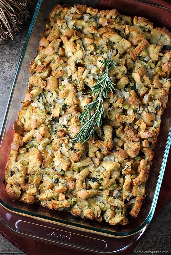 Traditional Herb Stuffing is very easy to make and filled with fresh, flavorful herbs. It'll be a hit on any Thanksgiving table! | www.persnicketyplates.com #thanksgiving #stuffing #herbstuffing #easyrecipe #sidedish overhead shot of herb stuffing in a baking dish topped with rosemary
