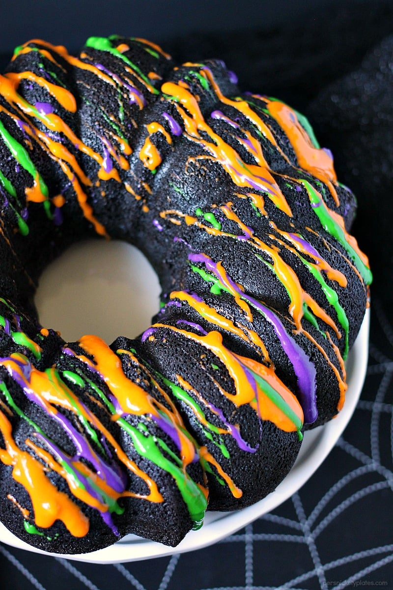 Halloween Chocolate Tunnel Cake is a moist, from scratch, dark chocolate cake filled with a tunnel of orange cheesecake center and drizzled with a cream cheese frosting. Just the right amount of festive and spooky for your Halloween party! | www.persnicketyplates.com