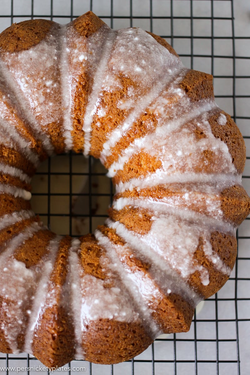 butterscotch bundt cake with powdered sugar glaze on a cooling rack