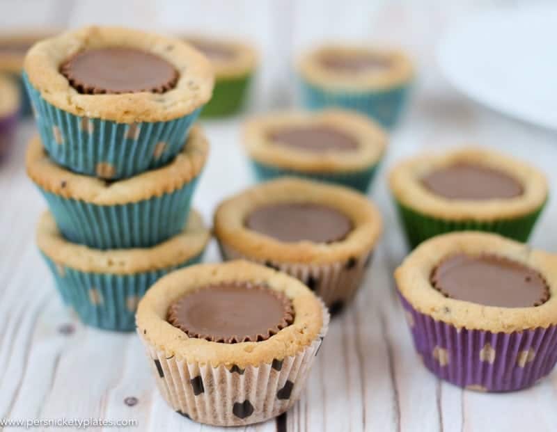 Chocolate Chip Peanut Butter Cookie Cups are only two ingredients and are ready in just 20 minutes. Perfect for a last minute bake sale, class treat, or craving! | www.persnicketyplates.com #easydessert #cookie #cookiecups #semihomemade #dessert stack of chocolate chip peanut butter cookie cups