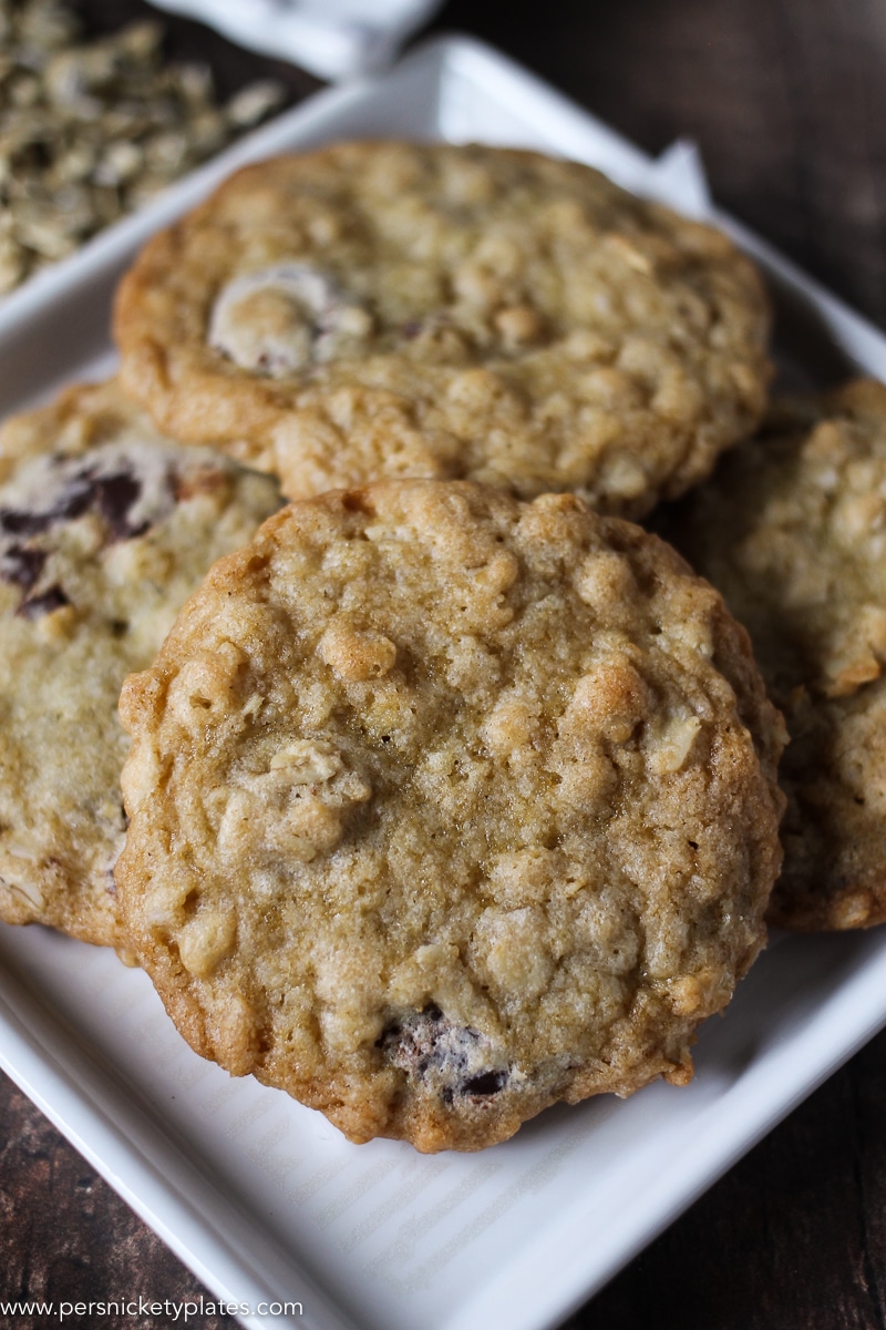close up of several ranger cookies on white plate.
