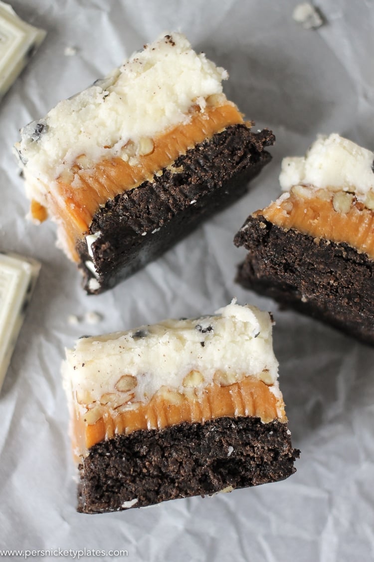 three cookies and cream caramel layer bars on parchment paper