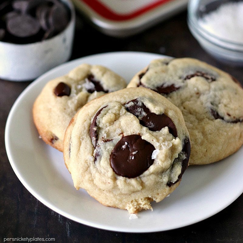Once you try these thick, chewy, cake-like Salted Chocolate Chip Cookies, you're going to forget about all your other chocolate chip cookie recipes! | www.persnicketyplates.com plate of three Salted Chocolate Chip Cookies