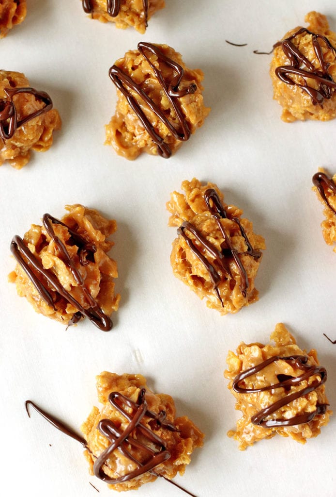 overhead shot of cornflake cookies on parchment paper, drizzled with chocolate.