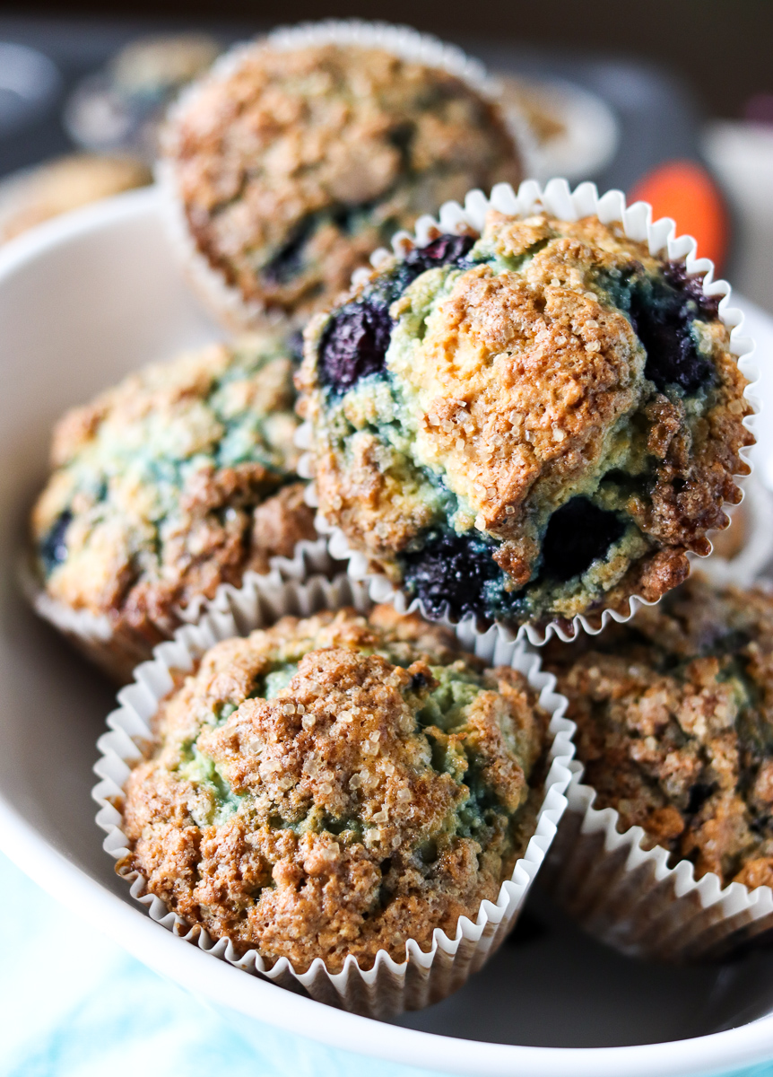 These Blueberry Muffins have a tender, buttermilk crumb, are full of blueberry flavor, and are topped with a crunchy sugary topping. Start your day off right with a batch of the best blueberry muffins! | www.persnicketyplates.com bowl full of blueberry muffins