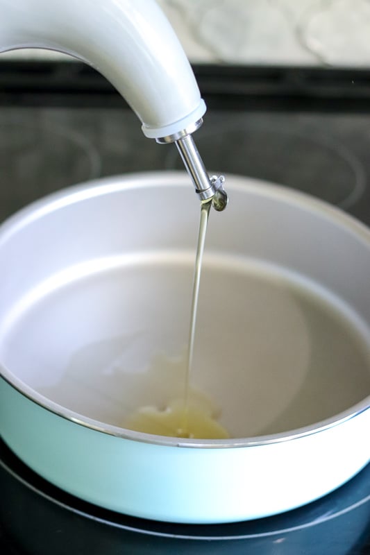 olive oil pouring into a skillet on stove