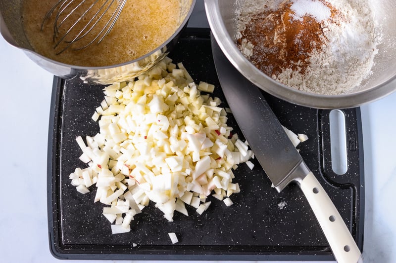 chopped apples on cutting board with mixing bowls