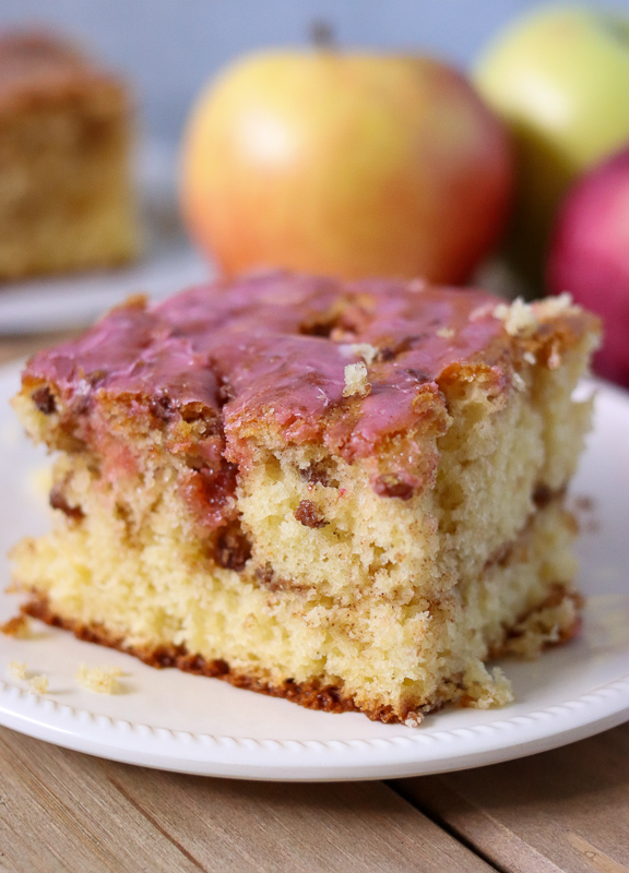 honey bun cake slice with pink frosting on white plate
