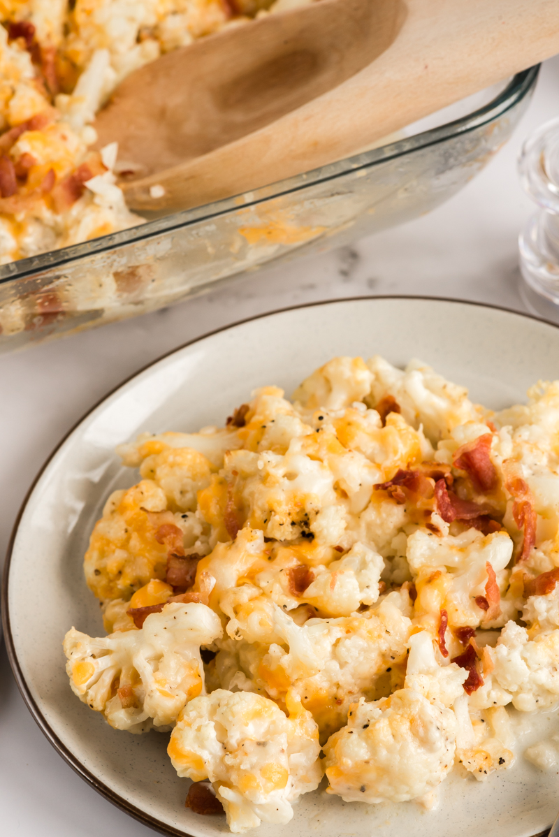 plate of cauliflower casserole next to serving dish
