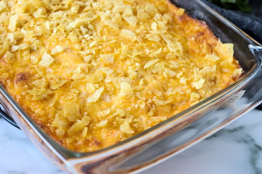 baking dish of cheesy potato casserole topped with potato chips