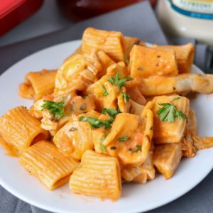 rosa pasta on a white plate topped with parsley
