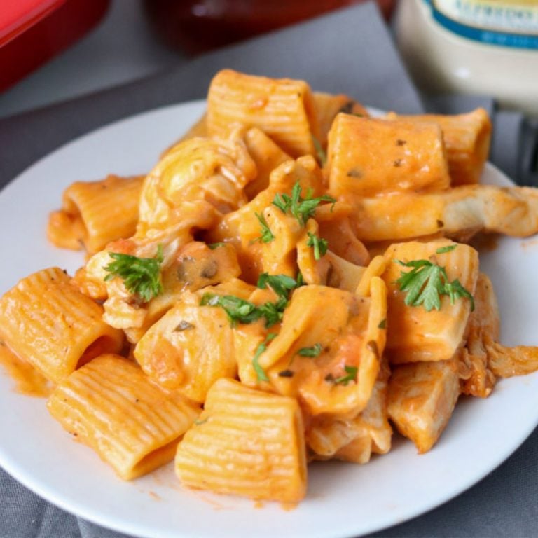 rosa pasta on a white plate topped with parsley