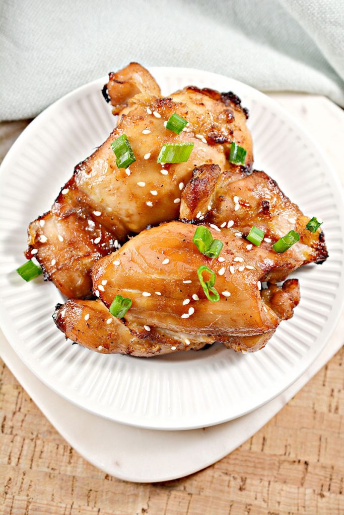 overhead shot of sticky chicken on white plate