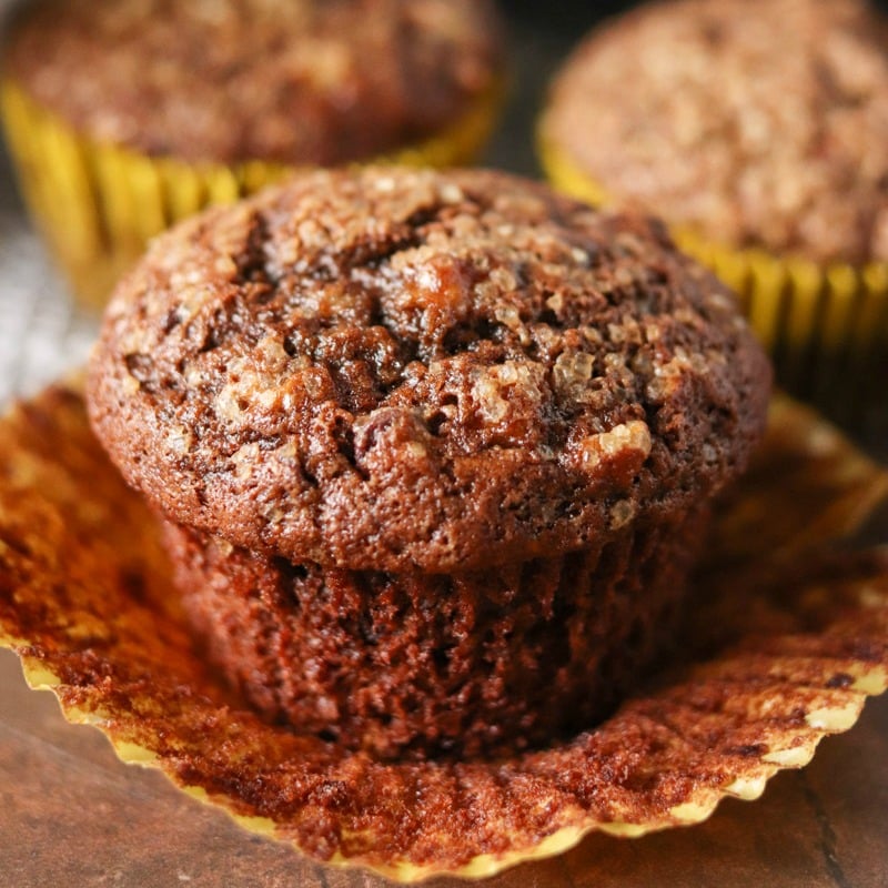 single chocolate banana muffin sitting in a cupcake wrapper.