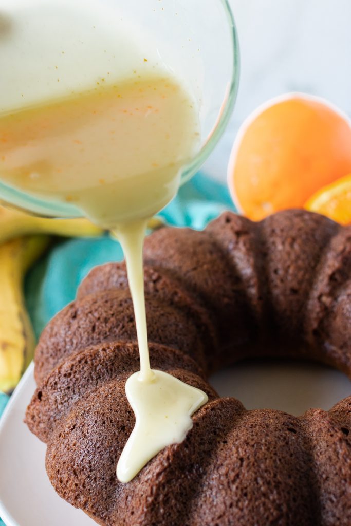 glaze being poured onto a bundt cake