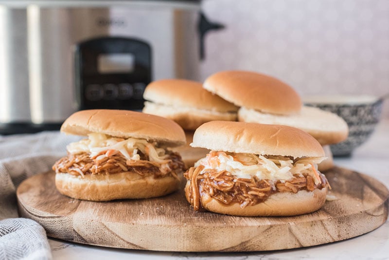 platter of bbq chicken sandwiches topped with cole slaw