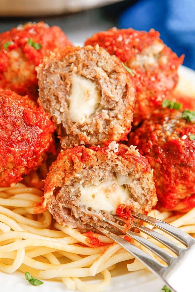 fork poking into a mozzarella stuffed meatball.