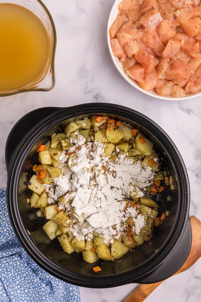 overhead shot of pot with flour sprinkled over potatoes.