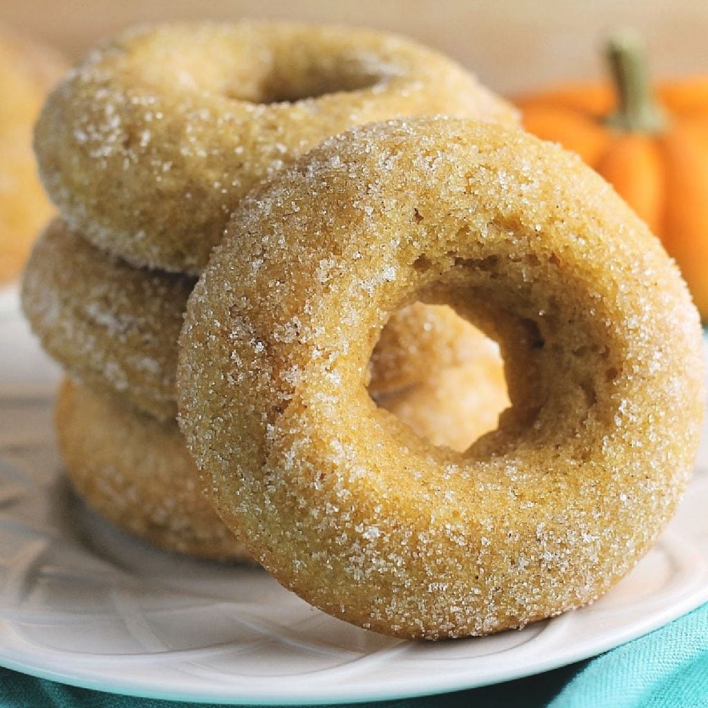 stack of cinnamon sugar pumpkin donuts on white plate