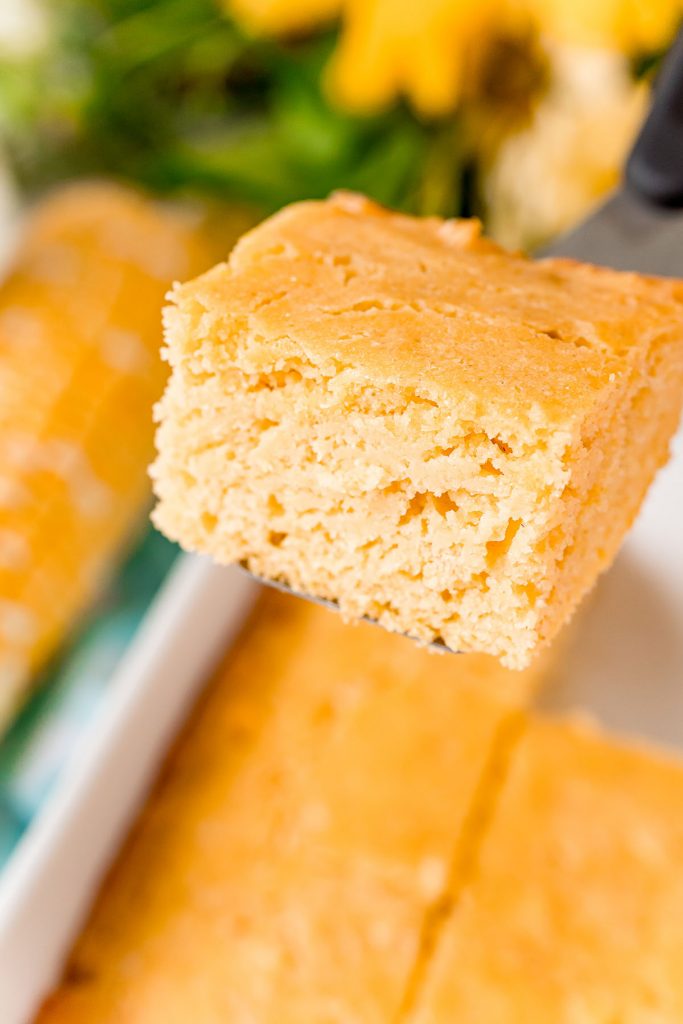 slice of cornbread being raised from baking dish