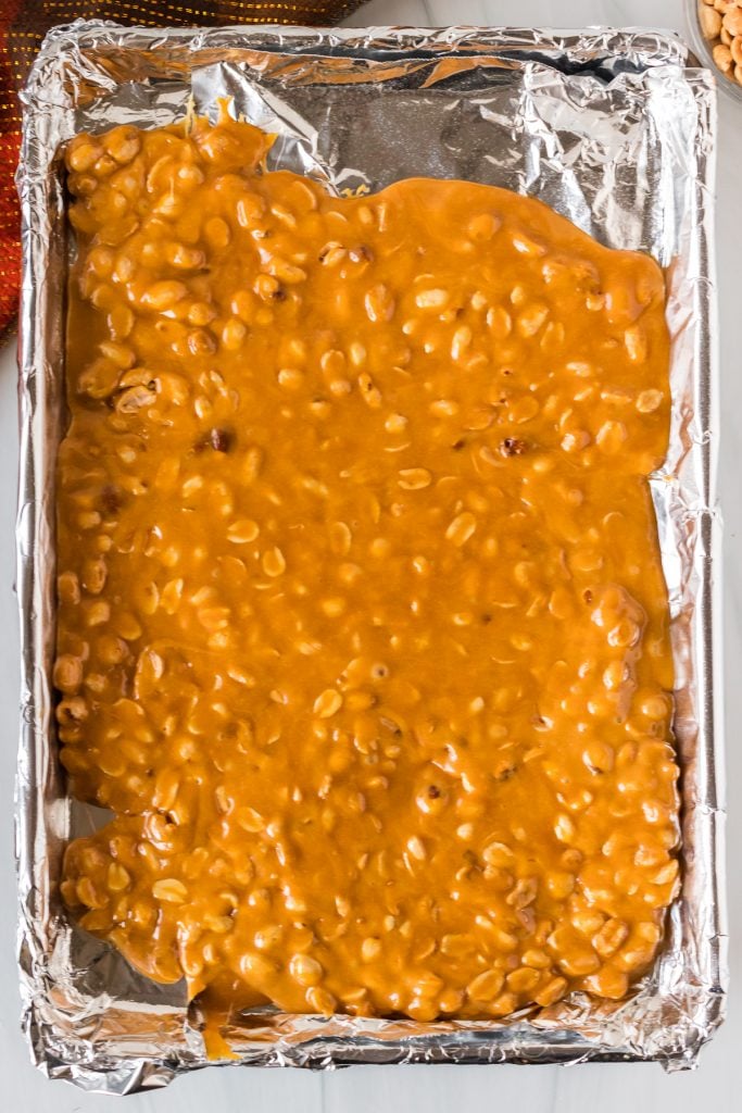 peanut brittle poured onto a baking sheet