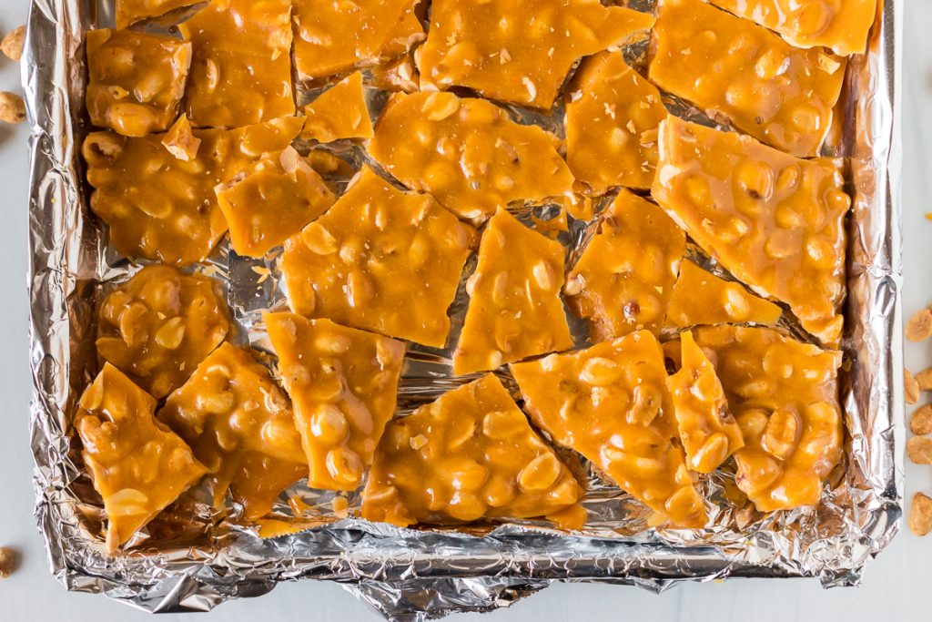 broken peanut brittle on a baking sheet