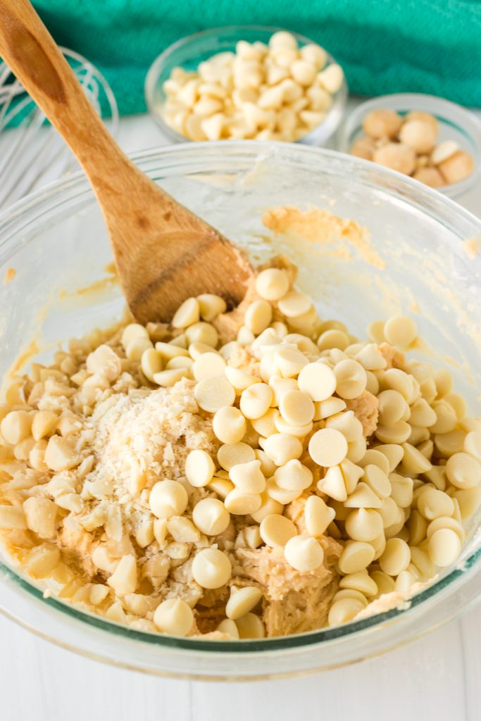 cookie dough in a mixing bowl topped with white chocolate chips