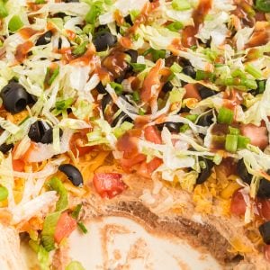 layered taco dip with a scoop taken out of the corner