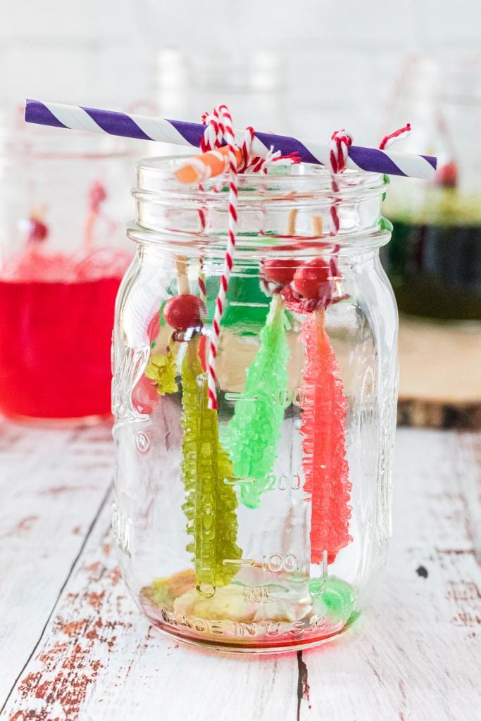 three rock candy stick hanging in a mason jar