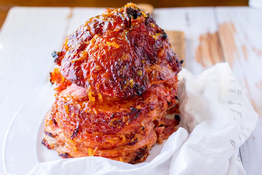 baked ham in a dish surrounded by a white towel