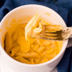 bite of mac n cheese on a fork from a mug