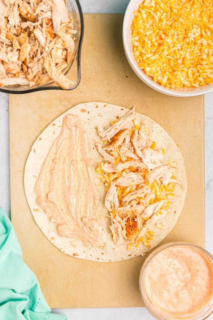 overhead shot of tortilla covered in jalapeno sauce, cheese, and chicken.