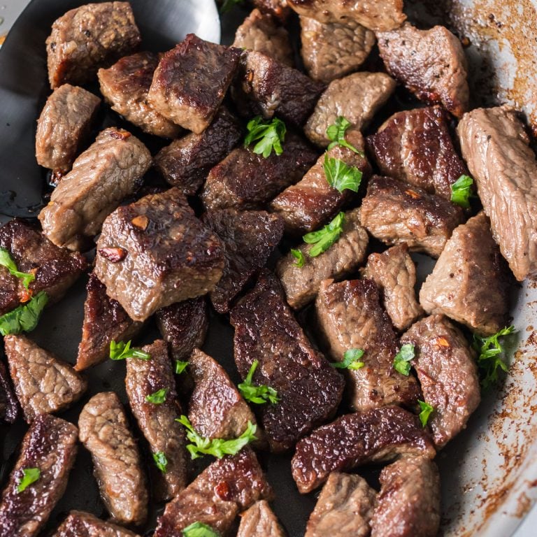 close up of garlic steak bites topped with parsley