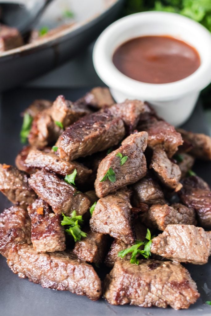 plate of steak bites with a bowl of dip