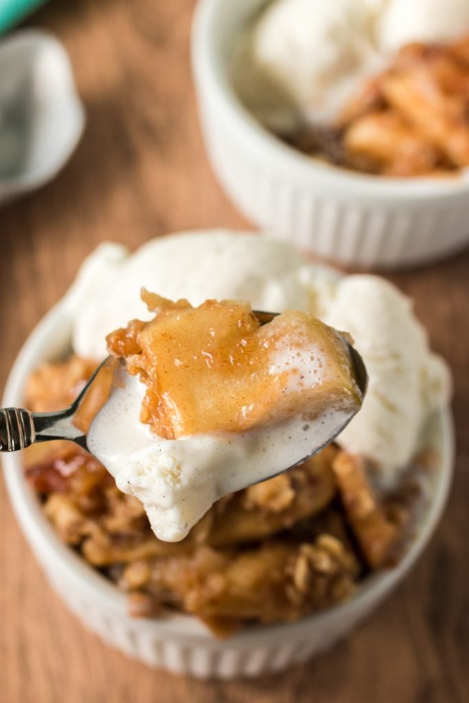 spoonful of apple crisp and drippy vanilla ice cream