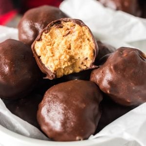 bowl of chocolate covered peanut butter balls with a bite taken out of one