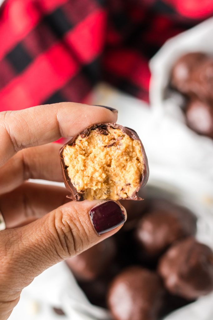 hand holding a pb rice krispie ball with a bite taken out of it