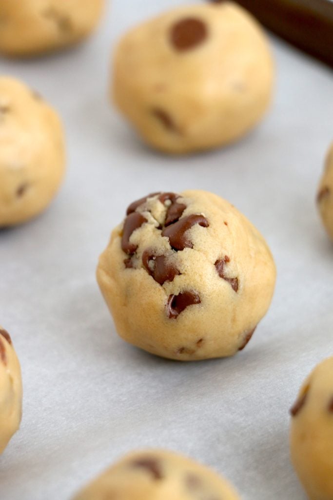 closeup of a chocolate chip cookie dough truffle on a baking sheet