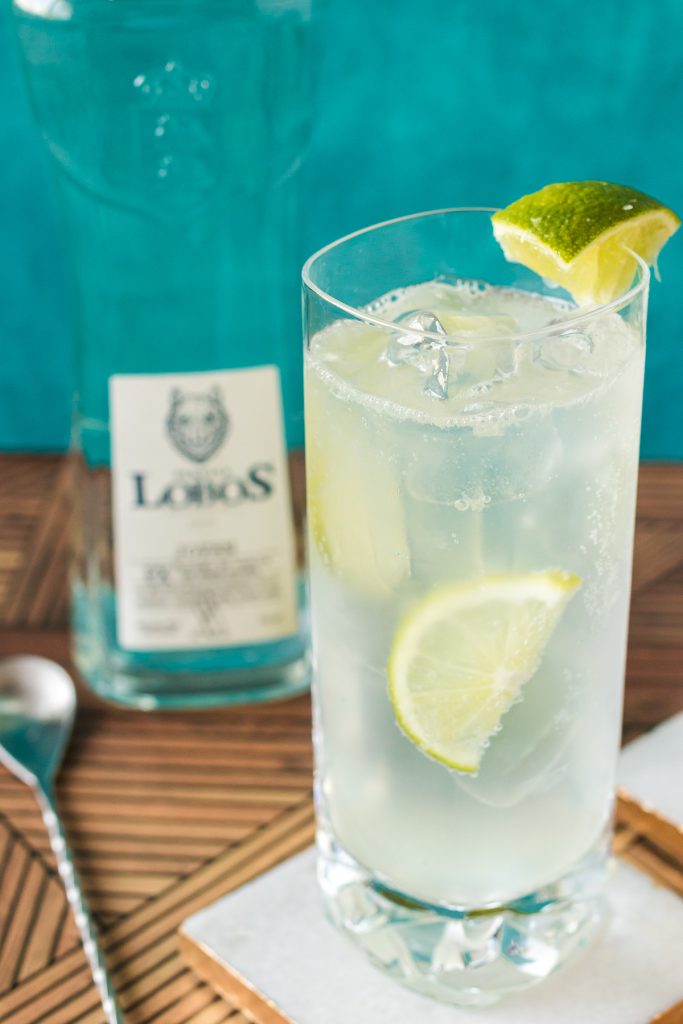 ranch water cocktail with lime next to a bottle of tequila