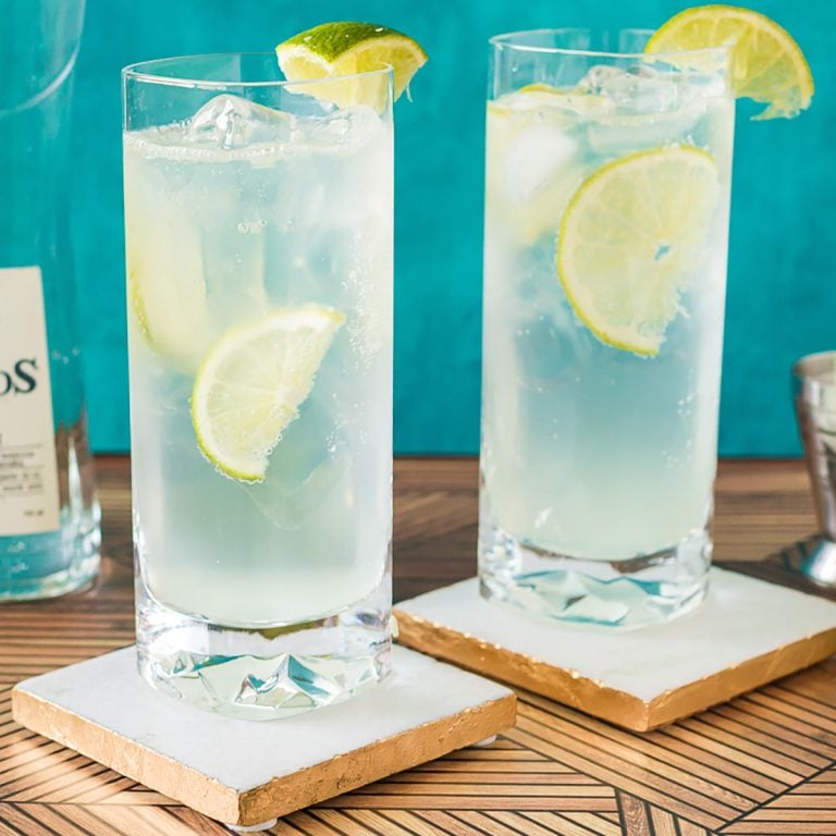 two ranch water cocktails with lime wedges on coasters