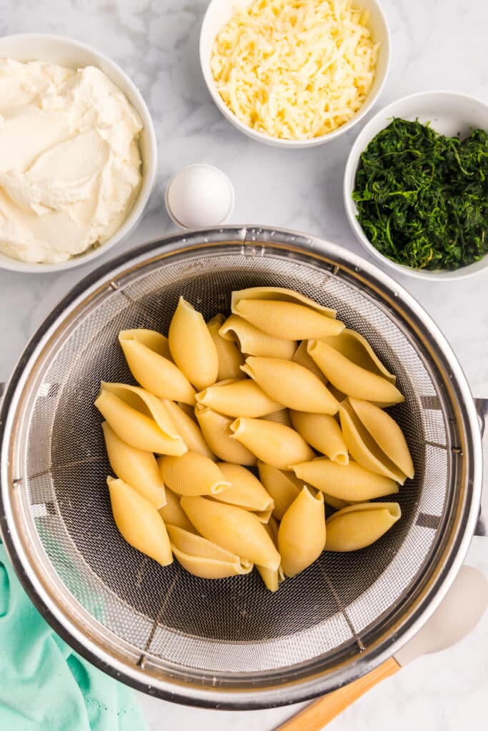 parboiled jumbo shells in a colander.
