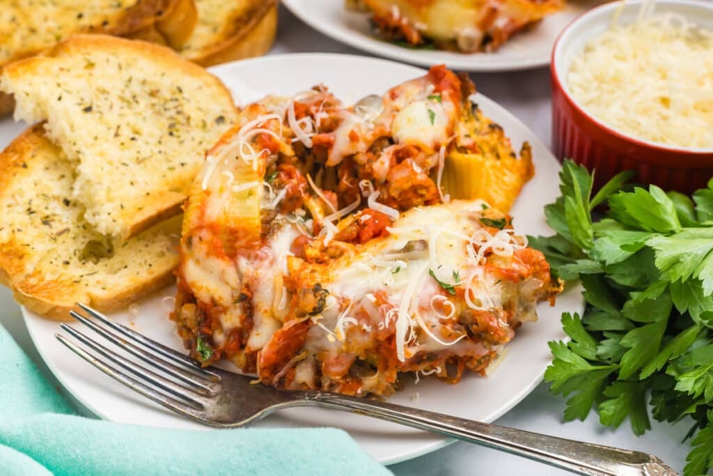 plate of stuffed shells with garlic bread.